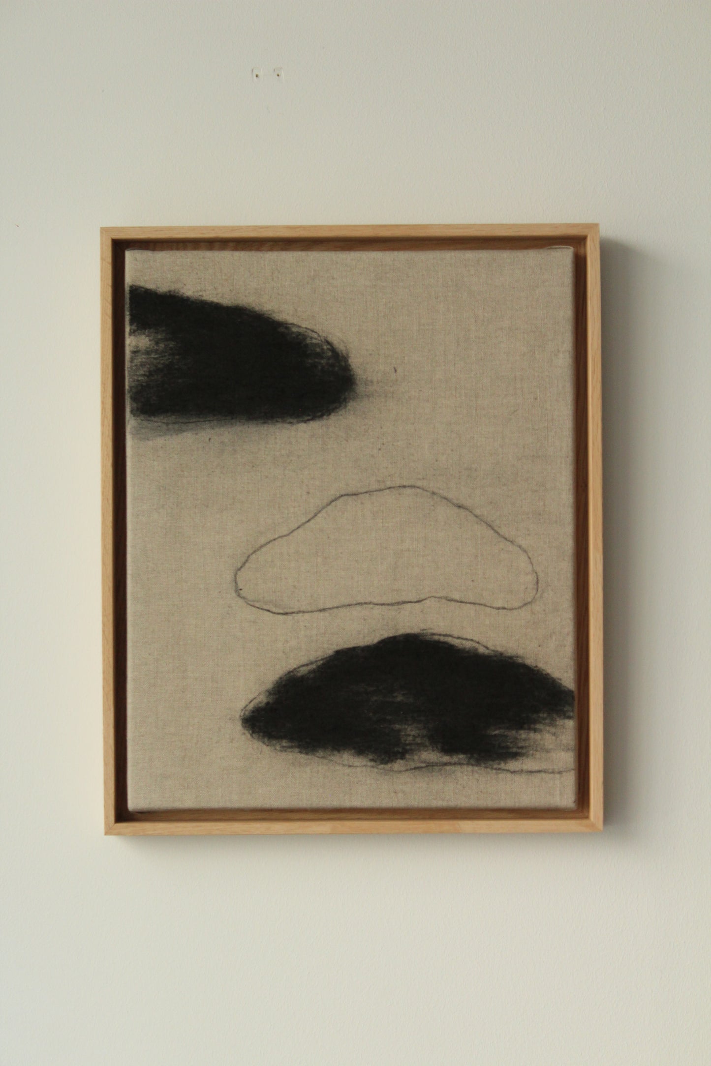 Three black clouds on linen